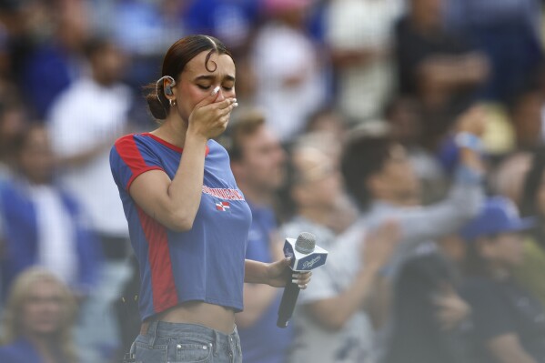 Music artist Nezza reacts after singing the national anthem prior to a baseball game between the Los Angeles Dodgers and the San Francisco Giants in Los Angeles, Saturday, June 14, 2025. (AP Photo/Jessie Alcheh,File)