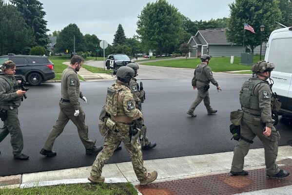 Police deploy as a manhunt is underway for a shooter that targeted two state lawmakers, in Brooklyn Park, Minn. on Saturday, June 14, 2025. (AP Photo/Tim Sullivan)