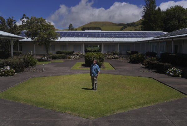 John O'Meara, chief scientist at the W.M. Keck Observatory, stands for a portrait in the center of a patch of grass in the exact size and shape of a single mirror in the Keck telescopes, in Kamuela, Hawaii, on Sunday, July 16, 2023. (AP Photo/Jessie Wardarski)
