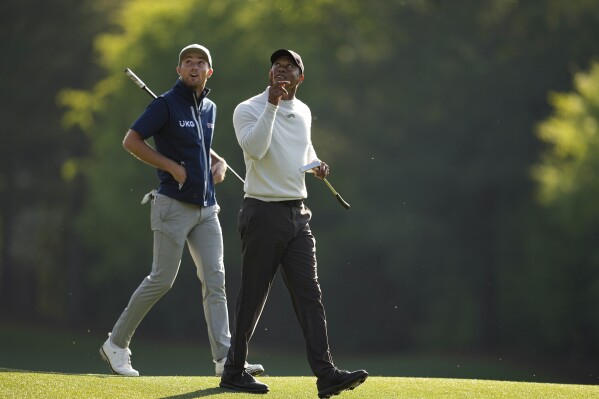 Will Zalatoris, left, and Tiger Woods walk to the12th green during a practice round in preparation for the Masters golf tournament at Augusta National Golf Club Monday, April 8, 2024, in Augusta, Ga. (AP Photo/George Walker IV)