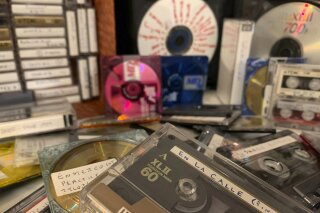 A stack of cassettes, MiniDiscs and CDs representing some of AP journalist Jaime Holguin’s decades-rich audio archive sit on a table, Sunday, July 12, 2020, in New York. (AP Photo/Jaime Holguin)