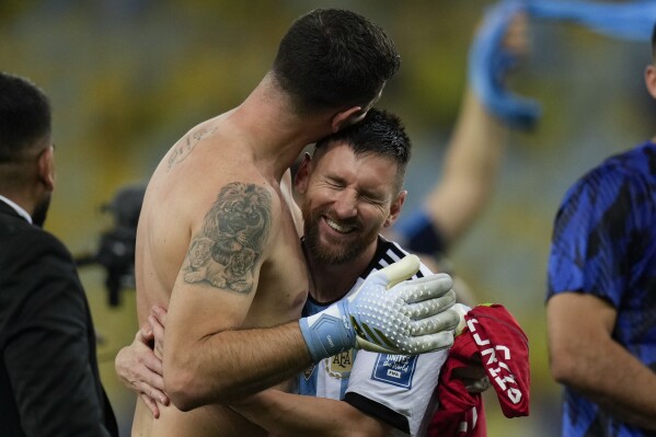 Argentina's Lionel Messi embraces teammate, goalkeeper Emiliano Martinez, as they celebrate their team's 1-0 victory over Brazil at the end of a qualifying soccer match for the FIFA World Cup 2026, at the Maracana stadium in Rio de Janeiro, Brazil, Tuesday, Nov. 21, 2023. It was Brazil's first home defeat ever in a World Cup qualifying game. (AP Photo/Silvia Izquierdo)