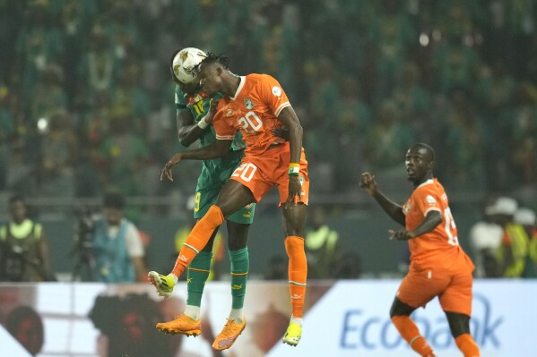Senegal's Moussa Niakhate, left, challenges for the ball with Ivory Coast's Christian Kouame during the African Cup of Nations round of 16 soccer match between Senegal and Ivory Coast, at the Charles Konan Banny stadium in Yamoussoukro, Ivory Coast, Monday, Jan. 29, 2024. (AP Photo/Themba Hadebe)
