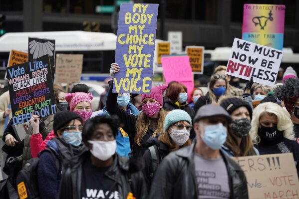People march during the Women's March in downtown Chicago, Saturday, Oct. 17, 2020.  Dozens of Women's March rallies were planned from New York to San Francisco to signal opposition to President Donald Trump and his policies, including the push to fill the seat of late Supreme Court Justice Ruth Bader Ginsburg before Election Day. (AP Photo/Nam Y. Huh)