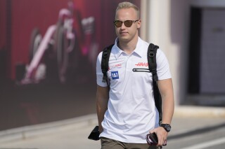 FILE - Haas driver Nikita Mazepin of Russia arrives to the Losail International Circuit in Losail, Qatar, Thursday, Nov. 18, 2021 ahead of the Qatar Formula One Grand Prix. The General Court of the European Union says ex-Formula One driver Nikita Mazepin should be removed from the EU lists of persons subjected to restrictive measures for their role in Russia’s war against Ukraine. Mazepin was added to the list of people sanctioned by the 27-nation bloc two years ago in the wake of Russia’s invasion because of his father’s connections to the Kremlin. (AP Photo/Darko Bandic, File)