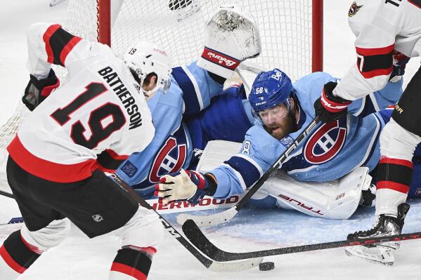 Ottawa Senators Drake Batherson (19) moves in on Montreal Canadiens' goaltender Jake Allen as Canadiens' David Savard attempts to block the shot during the second period of an NHL hockey game, Tuesday, Jan. 31, 2023 in Montreal. (Graham Hughes/The Canadian Press via AP)