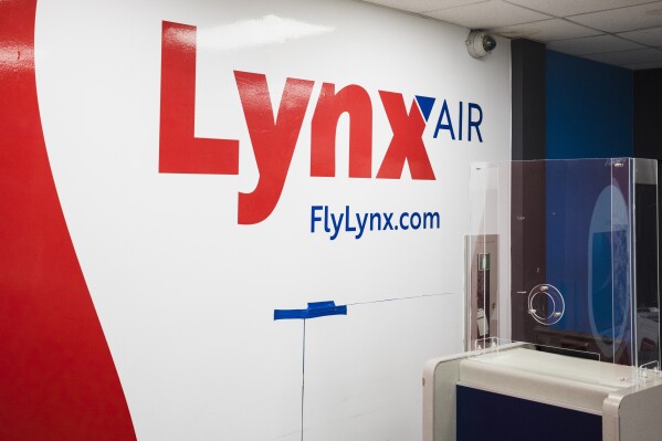 Lynx Air signage is displayed at the John C. Munro Hamilton International Airport in Hamilton, Ontario, Friday, Feb. 23, 2024. Officials with the Calgary-based company announced that it is ceasing operations after filing for creditor protection. (Nick Iwanyshyn/The Canadian Press via AP)