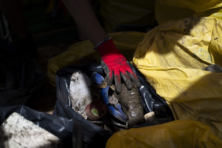 Voluntários separam o lixo coletado em seu barco enquanto participam do evento Plastic Cup perto de Tiszaroff, Hungria, na quarta-feira, 2 de agosto de 2023. (AP Photo/Denes Erdos)