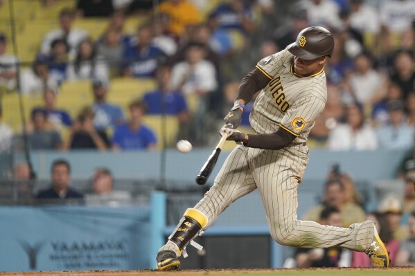 San Diego Padres left fielder Juan Soto hits a tie breaking three-run home run during the ninth inning of a baseball game against the Los Angeles Dodgers, Monday, Sept. 11, 2023, in Los Angeles. Trent Grisham and Fernando Tatis Jr. also scored. (AP Photo/Ryan Sun)