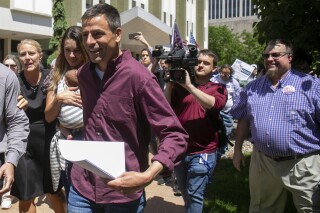 FILE - Michigan gubernatorial candidate Ryan Kelly leaves the U.S. District Court in Grand Rapids, Mich., with his family and supporters on June 9, 2022. The former Republican candidate for Michigan governor pleaded guilty on July 27, 2023, to a misdemeanor charge for his participation in the U.S. Capitol riot on Jan. 6, 2021. (Daniel Shular/The Grand Rapids Press via AP)