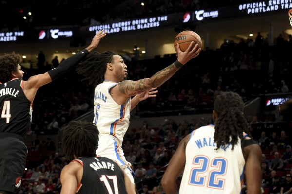 Oklahoma City Thunder forward Jaylin Williams, right, drives to the basket against Portland Trail Blazers guard Matisse Thybulle, left, during the first half of an NBA basketball game in Portland, Ore., Sunday, Nov. 19, 2023. (AP Photo/Steve Dykes)