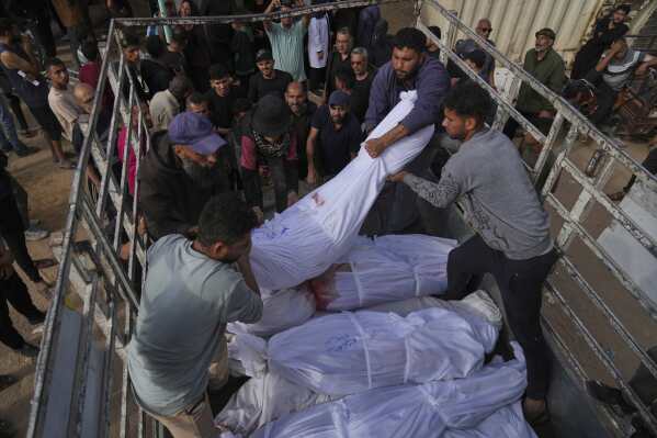 Palestinians load bodies of their relatives killed in the Israeli army airstrikes in Jabalia, northern Gaza Strip, on Wednesday, May 14, 2025. According to local hospitals, 48 people were killed in the strikes, including 22 children. (AP Photo/Jehad Alshrafi)