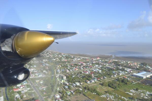 File - Georgetown, Guyana is seen over the propeller of a plane headed to Kaieteur Falls, Guyana, March 7, 2016. The former leader of Guyana’s Environmental Protection Agency, Vincent Adams, is criticizing the government's plan to use satellites to monitor oil spills in the South American nation’s waters, saying to the Associated Press on Jan. 24, 2023 that the only proper way of minimizing oil spills is to put spill-prevention experts onboard drilling ships and platforms. (AP Photo/Albert Stumm, File)