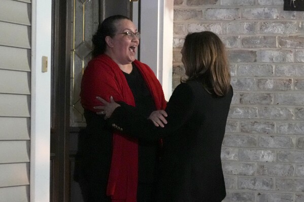 Democratic presidential nominee Vice President Kamala Harris, right, hugs a voter as she knocks on doors during a campaign stop in Reading, Pa., Monday, Nov. 4, 2024. (AP Photo/Jacquelyn Martin)