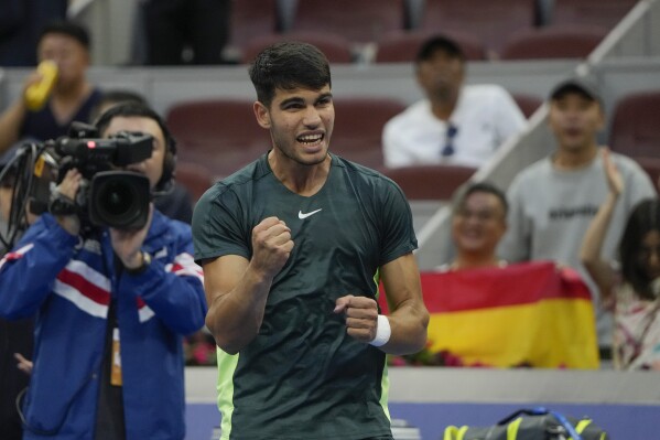 Carlos Alcaraz of Spain celebrates after defeating Lorenzo Musetti of Italy in the second round of the men's singles in the China Open tennis tournament at the Diamond Court in Beijing, Sunday, Oct. 1, 2023. (AP Photo/Andy Wong)