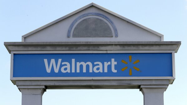 FILE - In this Tuesday, Sept. 3, 2019, file photo, a Walmart logo forms part of a sign outside a Walmart store, in Walpole, Mass. Walmart is rolling out a health care pilot program for its employees that will come up with a curated list of high quality providers but offer fewer choices than under the current plan. (AP Photo/Steven Senne, File)