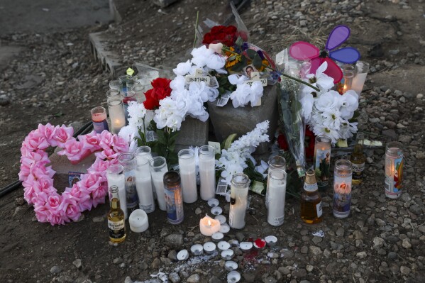 A memorial is displayed in an alley on L Street, Monday, Feb. 5, 2024, in Omaha, Neb., after two police officers, who were working off duty in Nebraska's largest city, shot and killed two men in an SUV. (Nikos Frazier/Omaha World-Herald via AP)