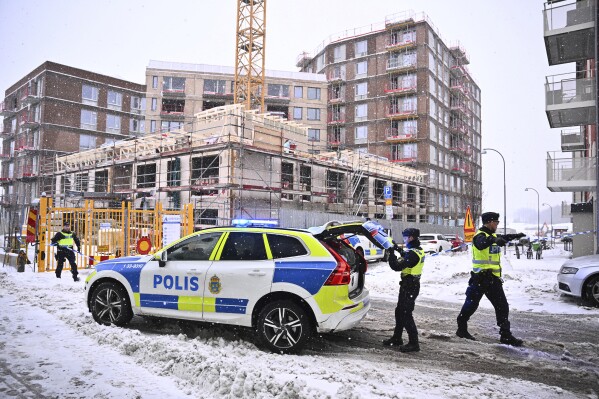 Swedish police arrive at the site where a construction elevator crashed to the ground on a building site seriously injuring several people in Sundbyberg, north of Stockholm, Sweden, Monday Dec. 11, 2023. The construction elevator fell 20 meters (66 feet) with four or five people inside in Sundbyberg, in the north of the city, Kurt Jonsson, a spokesman for the rescue service, told Swedish news agency TT. (Claudio Bresciani/TT News Agency via AP)