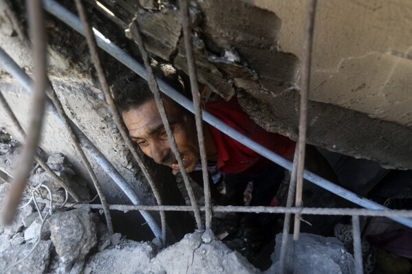 Người Palestine tìm kiếm những người sống sót dưới đống đổ nát của một tòa nhà bị phá hủy sau cuộc không kích của Israel vào trại tị nạn Khan Younis, phía nam Dải Gaza, Thứ Hai, ngày 6 tháng 11 năm 2023. (Ảnh AP / Mohammed Dahman)