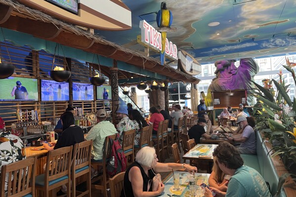 Patrons sit in the Margaritaville restaurant in New York's Times Square on Saturday, Sept. 2, 2023, following news of the death of Jimmy Buffett. (AP Photo/Bobby Caina Calvan)