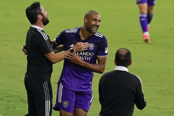 Orlando City forward Tesho Akindele, center, celebrates with coaches after scoring a goal against Toronto FC during the first half of an MLS soccer match, Saturday, May 22, 2021, in Orlando, Fla. (AP Photo/John Raoux)