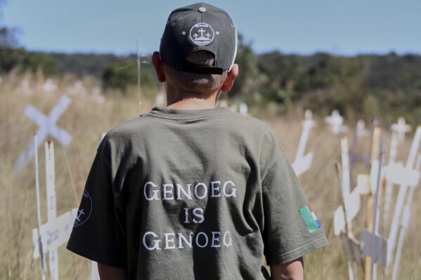Jano de Lange, wearing a shirt that reads, "Enough is enough," observes white crosses at the Witkruis Monument, near Polokwane, South Africa, May 24, 2025. (AP Photo/Mogomotsi Magome)