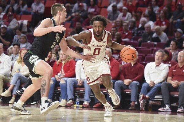 Oklahoma guard Le'Tre Darthard drives past Green Bay guard Foster Wonders during the first half of an NCAA college basketball game Saturday, Dec. 16, 2023, in Norman, Okla. (AP Photo/Kyle Phillips)