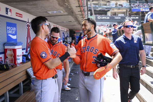 Houston Astros' Jeremy Peña, right, celebrates with Mauricio Dubón after scoring during the sixth inning of a baseball game against the Los Angeles Angels, Sunday, June 22, 2025, in Anaheim, Calif. (AP Photo/William Liang)