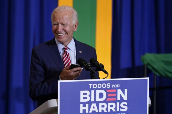 FILE - Then-Democratic presidential candidate Joe Biden plays music on a phone as he arrives to speak at a Hispanic Heritage Month event, Sept. 15, 2020, at Osceola Heritage Park in Kissimmee, Fla. (AP Photo/Patrick Semansky, file)