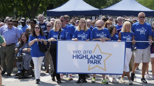 People participate in a community walk in Highland Park, Ill., Tuesday, July 4, 2023. One year after a shooter took seven lives at the city's annual parade, community members are planning to honor the victims and reclaim the space to move forward. (AP Photo/Nam Y. Huh)