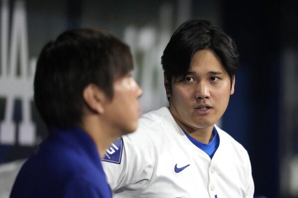 Los Angeles Dodgers' designated hitter Shohei Ohtani, right, chats with his interpreter Ippei Mizuhara during an exhibition baseball game between Team Korea and the Los Angeles Dodgers at the Gocheok Sky Dome in Seoul, South Korea, Monday, March 18, 2024. Ohtani’s interpreter and close friend has been fired by the Dodgers following allegations of illegal gambling and theft from the Japanese baseball star. (AP Photo/Lee Jin-man)