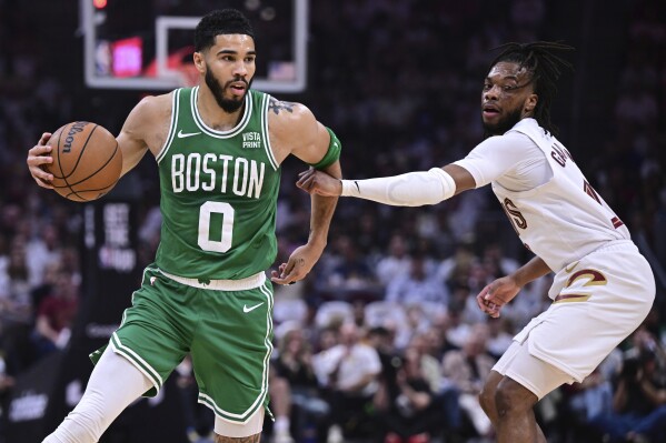 Boston Celtics forward Jayson Tatum (0) drives against Cleveland Cavaliers guard Darius Garland, right, during the first half of Game 4 of an NBA basketball second-round playoff series, Monday, May 13, 2024, in Cleveland. (AP Photo/David Dermer)