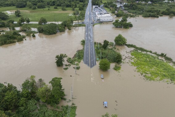 La Plata river floods a road after Tropical Storm Ernesto passed through Toa Baja, Puerto Rico, Wednesday, Aug. 14, 2024. (AP Photo/Alejandro Granadillo)