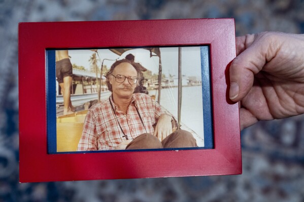 Cathy Votaw, 69, holds a photograph of her father, Albert Votaw, seen in Bangkok circa 1983 shortly before his death in a terror attack, Thursday, Feb. 27, 2025, in Washington. (AP Photo/Jacquelyn Martin)