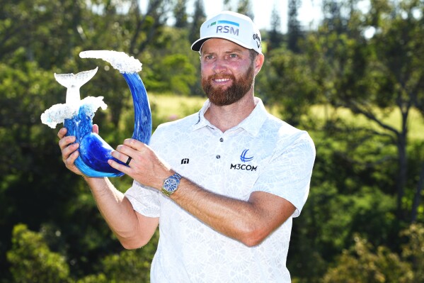 Chris Kirk holds the champions trophy after the final round of The Sentry golf event, Sunday, Jan. 7, 2024, at Kapalua Plantation Course in Kapalua, Hawaii. (AP Photo/Matt York)