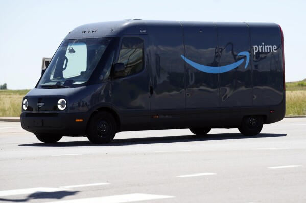 FILE- An driver drives a Rivian electric van as packages are delivered for Amazon Prime, Friday, Aug. 4, 2023, in Thornton, Colo. Electric vehicle maker Rivian said Tuesday, Nov. 7, 2023, that it will allow other companies to purchase its fleet of delivery vans and end its exclusive agreement with Amazon. (AP Photo/David Zalubowski, File)