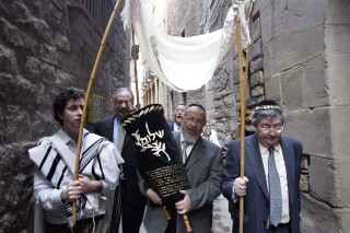 Members of the restored Synagogue of Barcelona carry the holy Torah to their new home in Barcelona, Spain, Sunday, Jan. 22, 2006. Spain's Catalonia suffered region some of the most virulent anti-Semitism of the Middle Ages, and most Jews were driven out nearly a century before all Jews were expelled from the rest of the country in 1492. Barcelona oldest synagogue, dating from the 9th century, has been restored, and recently received a gift of a medieval torah, the scrolled parchment bearing the first five books of the Old Testament in Hebrew. (AP Photo/Manu Fernandez)
