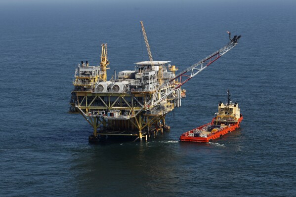FILE - A rig and supply vessel are pictured in the Gulf of Mexico, off the cost of Louisiana, April 10, 2011. The Biden administration's plan to protect an endangered species of whale by scaling back an auction of oil and gas drilling leases in the Gulf of Mexico is being challenged by the oil industry. The conflicting federal lawsuits — one filed Thursday, Aug. 24, 2023, in southwest Louisiana by oil interests, the other announced Friday, Aug. 25, in Washington by the organization Earthjustice — focus on a planned sale of oil and gas leases set for Sept. 27 in New Orleans. (AP Photo/Gerald Herbert, File)