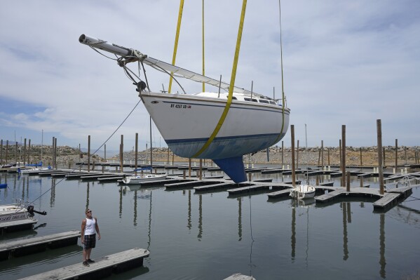 Sail boats are hoisted back into the Great Salt Lake Marina on June 6, 2023, in Magna, Utah. Sailors back out on the water are rejoicing after a snowy winter provided temporary reprieve. (AP Photo/Rick Bowmer)