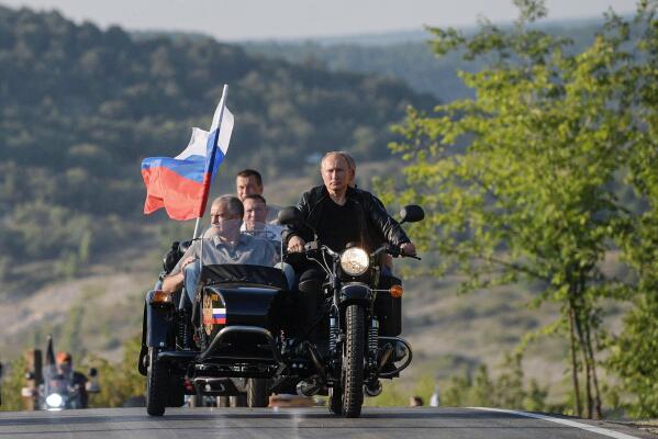 Russian President Vladimir Putin, left, drives a motorbike decorated with a Russian national flag, with Crimean leader Sergei Aksenov, in sidecar, and Sevastopol Gov. Mikhail Razvozhaev, behind, during the Babylon's Shadow bike show camp in Sevastopol, Crimea, on Saturday, Aug. 10, 2019. Putin sent forces into Ukraine on Feb. 24, 2022, and appears determined to prevail -- ruthlessly and at all costs. (Alexei Druzhinin, Sputnik, Kremlin Pool Photo via AP)
