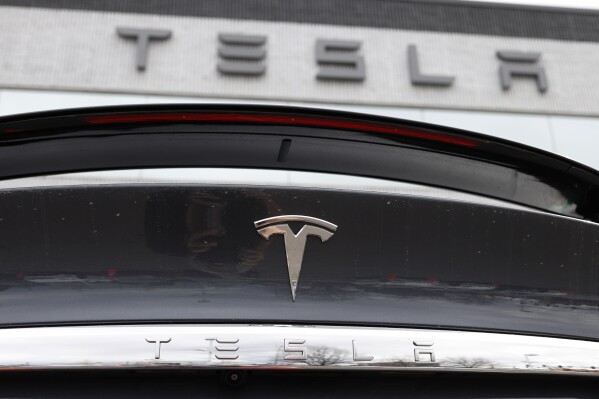 FILE - The company logo shines off the rear deck of an unsold 2020 Model X at a Tesla dealership in Littleton, Colo, on April 26, 2020. A conglomerate of unions in Norway on Wednesday Dec. 6, 2023 said it will take action against Tesla in solidarity with their Swedish colleagues who are demanding that the Texas-based automaker sign a collective bargaining agreement. (APPhoto/David Zalubowski, File)