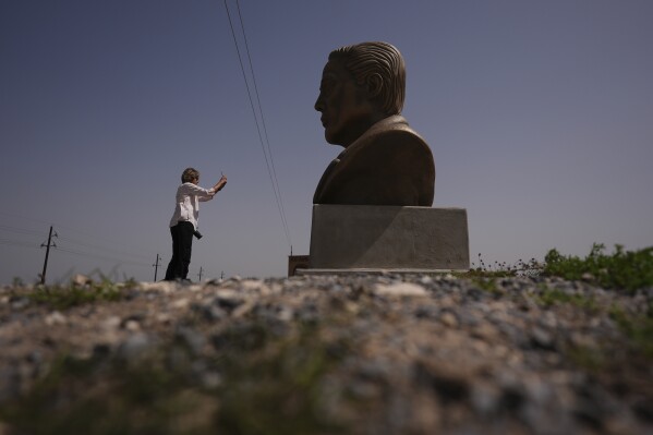 A visitor photographs a large bust of Elon Musk near SpaceX's Starbase as the Starship is prepared for a test flight in Boca Chica, Texas, March 5, 2025. (AP Photo/Eric Gay, File)