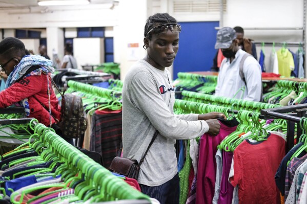 Apparel reseller Glen Kalungi chooses secondhand clothes at Green Shop, a chain specializing in used clothes, in Kampala, Uganda, Friday, Sept. 15, 2023. Downtown Kampala’s Owino Market has long been a go-to enclave for rich and poor people alike looking for affordable but quality-made used clothes, underscoring perceptions that Western fashion is superior to what is made at home. But, despite their popularity, secondhand clothes are facing increasing pushback. (AP Photo/Hajarah Nalwadda)