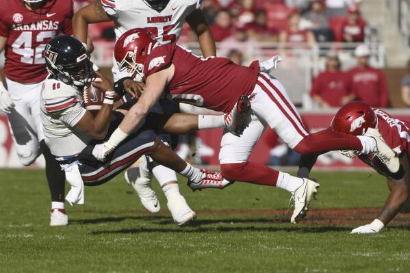 Liberty quarterback Johnathan Bennett (11) is tackled by Arkansas linebacker Bumper Pool, right, during the first half of an NCAA college football game Saturday, Nov. 5, 2022, in Fayetteville, Ark. (AP Photo/Michael Woods)