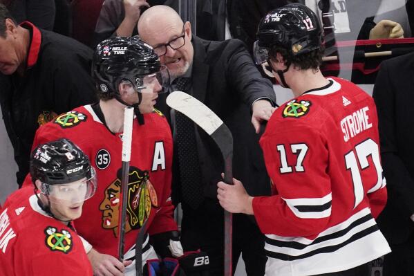 Chicago Blackhawks interim head coach Derek King, center, talks to right wing Patrick Kane, left, and center Dylan Strome during the third period of an NHL hockey game against the Vegas Golden Knights in Chicago, Wednesday, April 27, 2022. The Blackhawks won 4-3. (AP Photo/Nam Y. Huh)