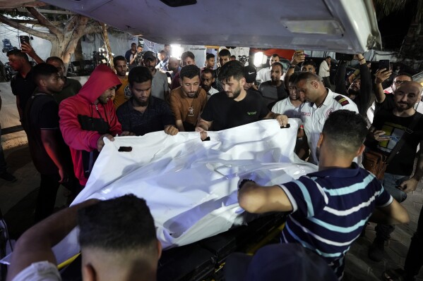 Palestinians move bodies of people killed in an Israeli bombardment on a residential building owned by the Akel family in Bureij refugee camp to the morgue at al-Aqsa Martyrs hospital in Deir al-Balah, central Gaza Strip, late Sunday, June 2, 2024. (AP Photo/Abdel Kareem Hana)