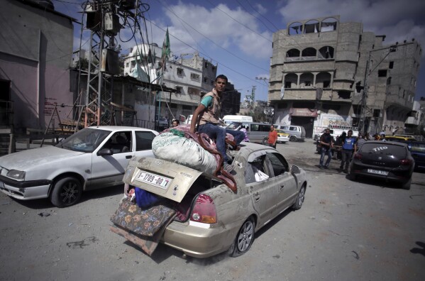 FILE - Palestinians salvage what little of their belongings they could from their homes during a 12-hour cease-fire in Gaza City's Shijaiyah neighborhood, July 26, 2014. An urban battle during the 2014 Gaza war offers a glimpse of what an Israeli ground offensive would look like, in 2023. (AP Photo/Khalil Hamra, File)