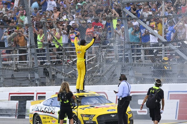 Ryan Blaney, center, celebrates with fans in the stands after winning a NASCAR Cup Series auto race at Talladega Superspeedway, Sunday, Oct. 1, 2023, in Talladega, Ala. (AP Photo/Julie Bennett)