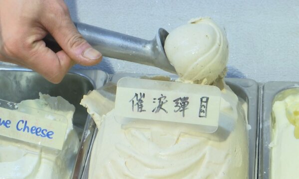 This May 4, 2020, image made from video shows a scoop of tear gas flavor ice cream, in Hong Kong. A Hong Kong ice cream shop has created this flavor using pepper, in memory of all the tear gas fired by the Hong Kong police in recent months. The flavor is a sign of support for the pro-democracy movement, which is seeking to regain its momentum during the coronavirus pandemic, the shop's owner said. (AP Photo)