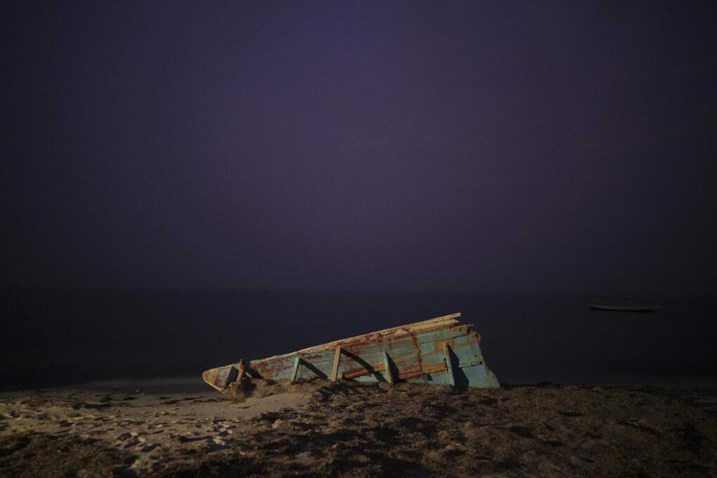 The wreck of a traditional Mauritanian fishing boat, known as a pirogue, also used by migrants to reach Spain's Canary Islands, sits on a beach near Nouadhibou, Mauritania, Thursday, Dec. 2, 2021. In 2021, at least seven boats appearing to be from Northwest Africa washed up in the Caribbean and in Brazil. All carried dead bodies. (AP Photo/Felipe Dana)